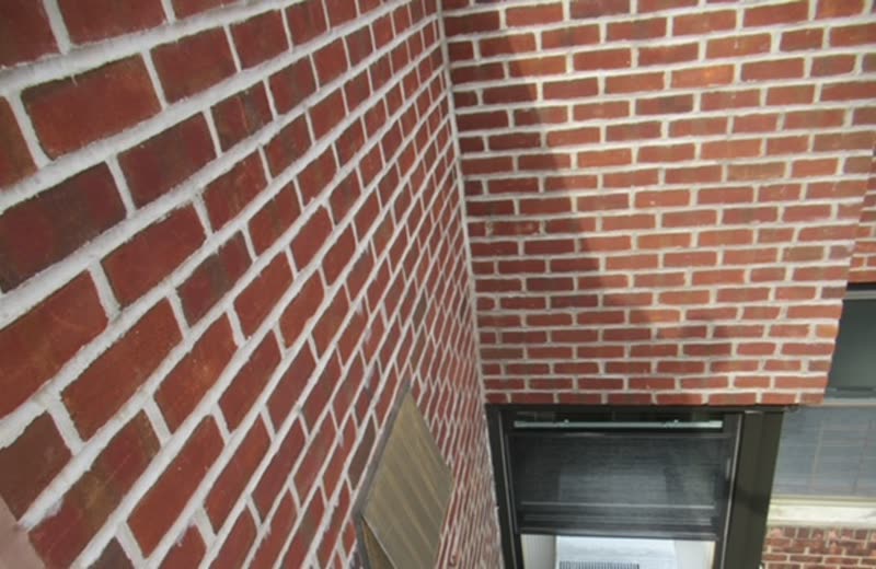 Brick facade and a window opening, looked at from grade