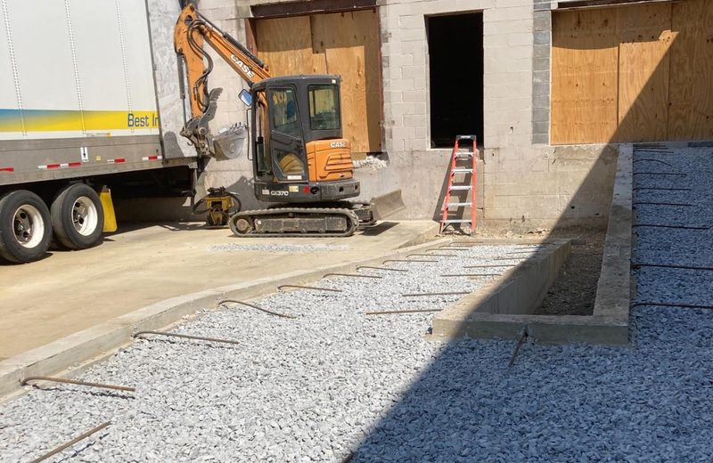 Excavation and stone base going in at the rear of the shell